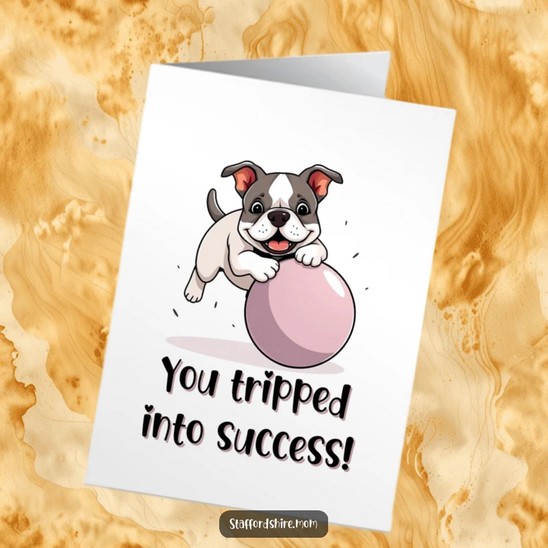 Funny free printable congratulations card: A silly Staffy Bull Terrier playfully tripping over an oversized ball, mid-tumble.
