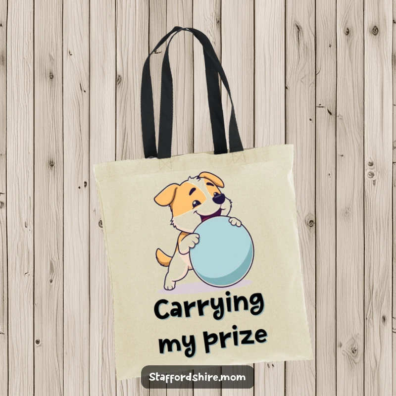 Funny Dog Tote Bag: A sturdy dog with a strong build joyfully fetching a large toy, perfect for carrying essentials.
