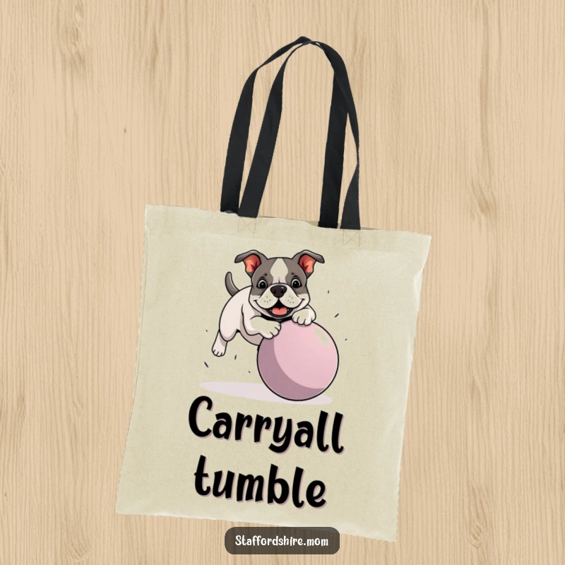 Funny Staffordshire Bull Terrier tote bag depicting a dog hilariously stumbling over a large ball, ideal for humorous and practical everyday use.